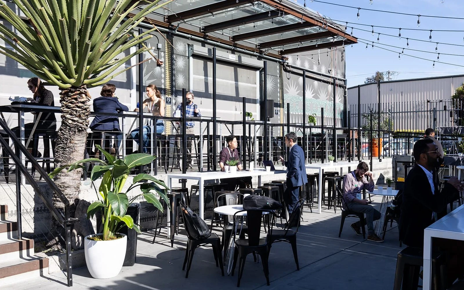 The outdoor patio at The Midway in San Francisco, with the venue&rsquo;s glass roll-up doors open behind it